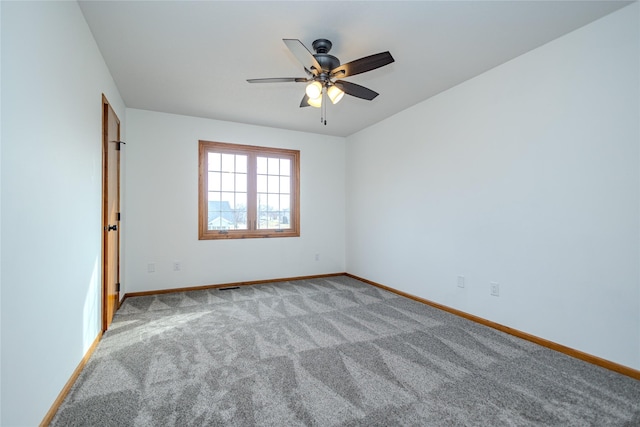 empty room featuring carpet, visible vents, ceiling fan, and baseboards