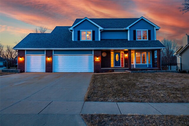 front of property with a yard, a porch, and a garage