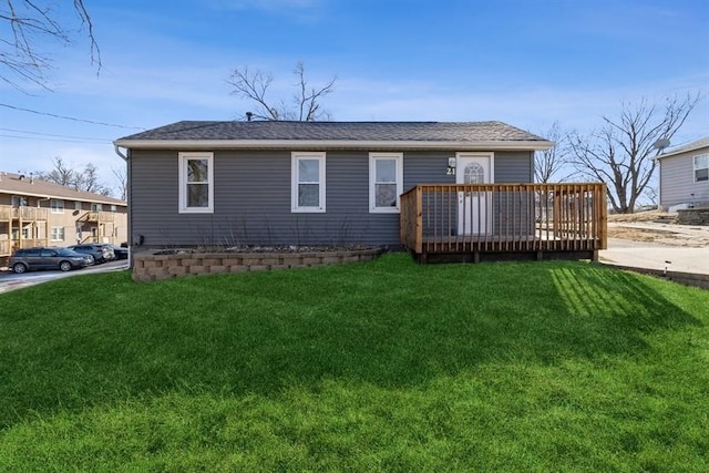 back of property with a wooden deck and a lawn