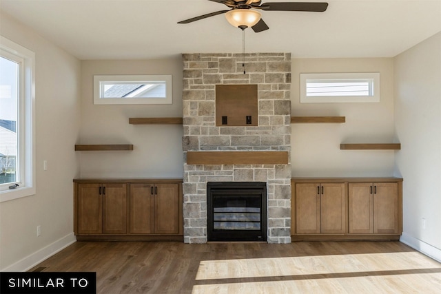 unfurnished living room featuring a fireplace, light wood-type flooring, and ceiling fan