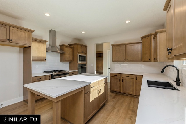 kitchen featuring wall chimney range hood, stainless steel appliances, decorative backsplash, sink, and light wood-type flooring