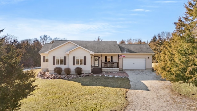 ranch-style home with covered porch, a front yard, and a garage