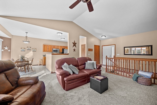 carpeted living room with ceiling fan and lofted ceiling