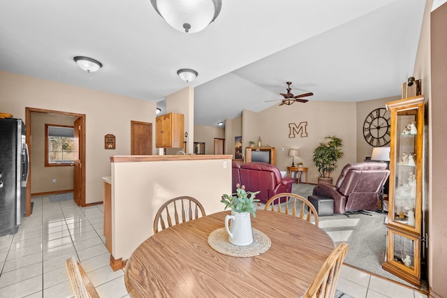 dining area featuring ceiling fan, light tile patterned floors, and lofted ceiling