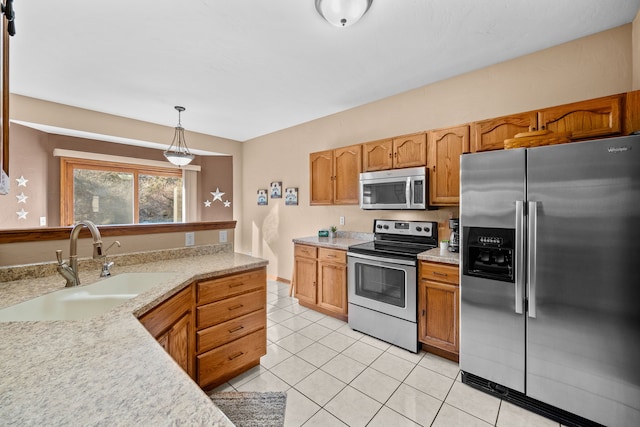 kitchen featuring sink, pendant lighting, light tile patterned floors, and appliances with stainless steel finishes