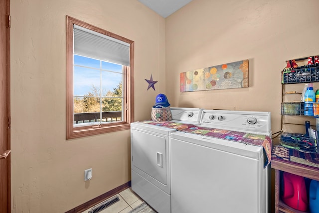 laundry room with light tile patterned flooring and washer and clothes dryer