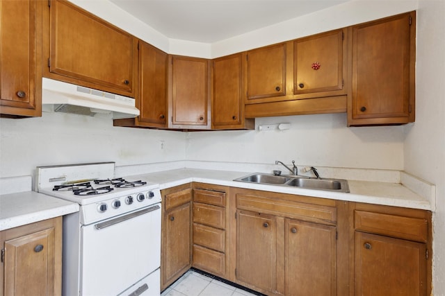 kitchen with light tile patterned floors, sink, and white range with gas cooktop