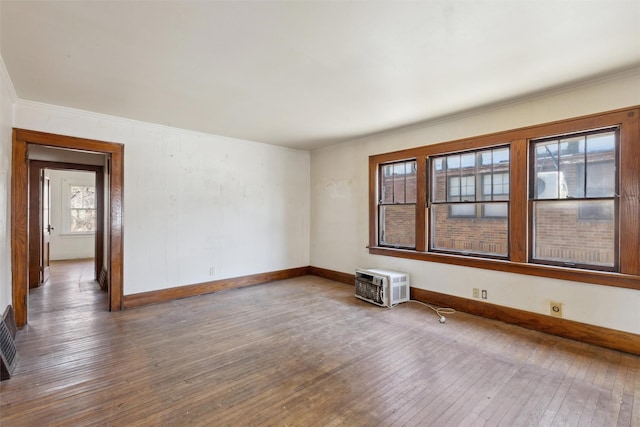 unfurnished room with hardwood / wood-style flooring and an AC wall unit