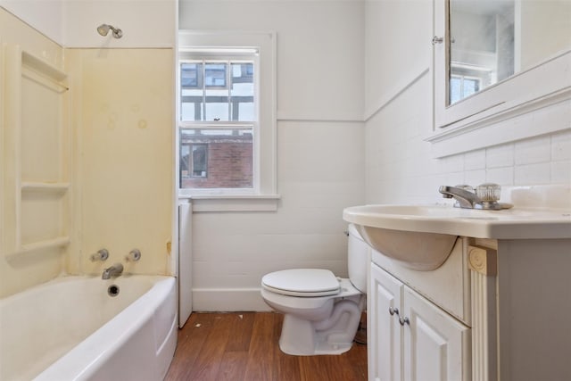 full bathroom with vanity, toilet,  shower combination, and hardwood / wood-style floors