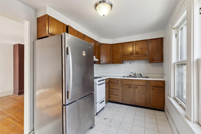 kitchen with sink, white range oven, and stainless steel fridge