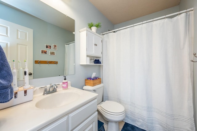 bathroom featuring a textured ceiling, toilet, and vanity