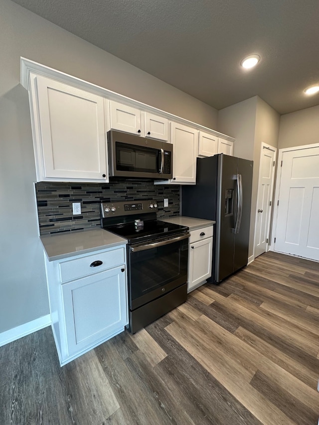 kitchen featuring decorative backsplash, dark wood-type flooring, white cabinets, and stainless steel appliances