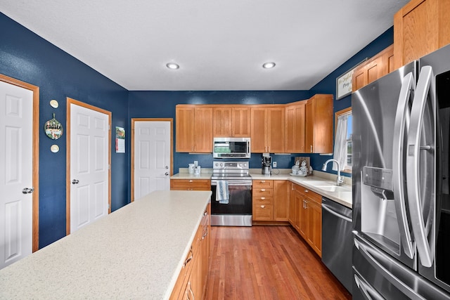 kitchen with sink, appliances with stainless steel finishes, and light wood-type flooring