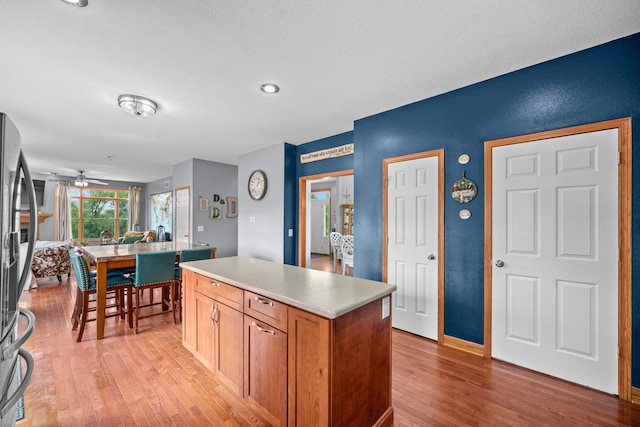 kitchen featuring a kitchen island, stainless steel refrigerator, and light hardwood / wood-style floors