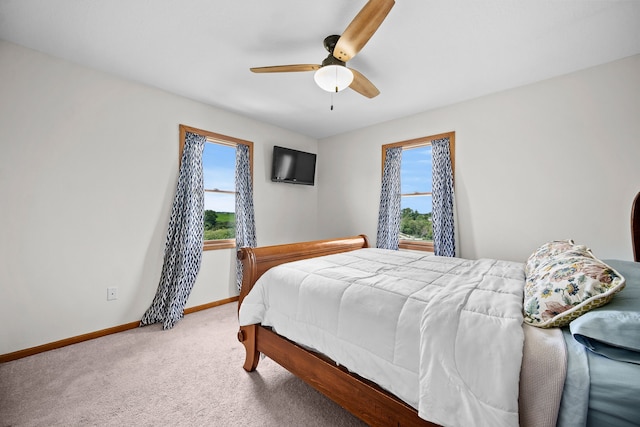 carpeted bedroom featuring multiple windows and ceiling fan