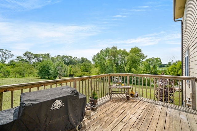 wooden terrace featuring a grill and a lawn