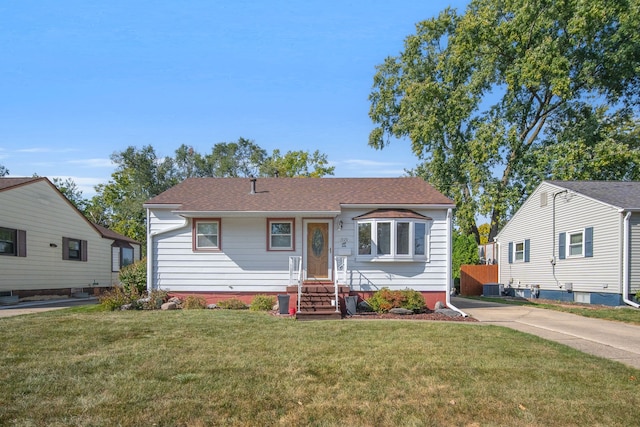 bungalow featuring cooling unit and a front lawn