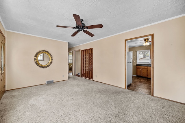 spare room with a textured ceiling, carpet flooring, ceiling fan, and ornamental molding