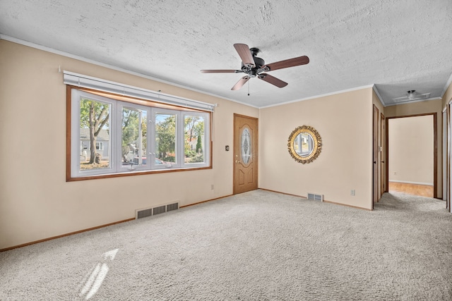 unfurnished living room featuring a textured ceiling, carpet floors, and ornamental molding