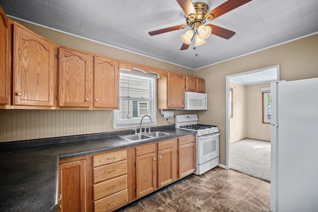 kitchen with ceiling fan, sink, white appliances, and dark colored carpet