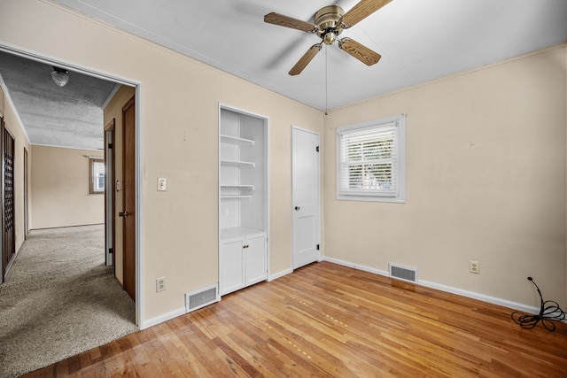 unfurnished bedroom with ceiling fan and light wood-type flooring