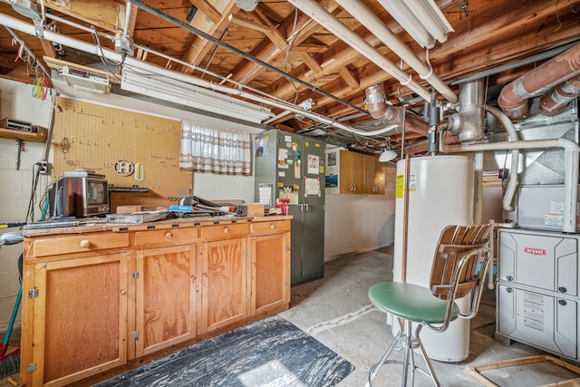 basement with gas water heater, a workshop area, and stainless steel refrigerator