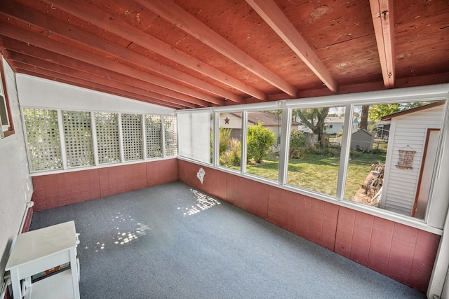 unfurnished sunroom with vaulted ceiling with beams