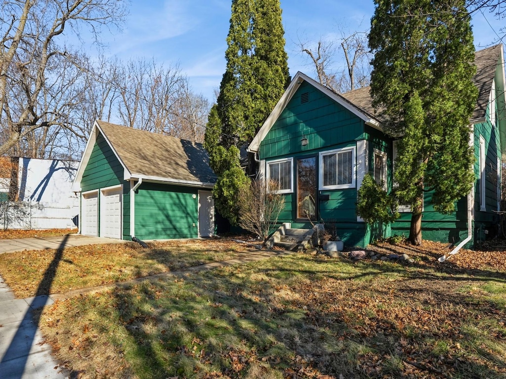 view of front of house with a front yard, an outdoor structure, and a garage