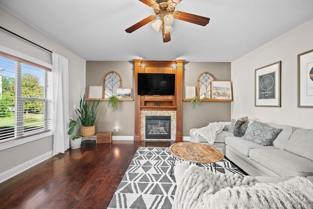 living room with ceiling fan, dark hardwood / wood-style flooring, and a tiled fireplace