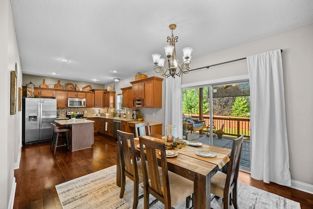 dining room with sink, dark wood-type flooring, and a chandelier