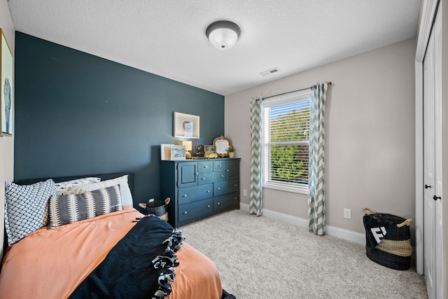 carpeted bedroom with a closet and a textured ceiling