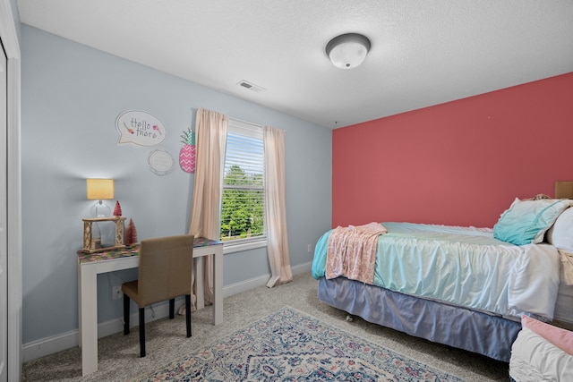 bedroom featuring light colored carpet and a textured ceiling