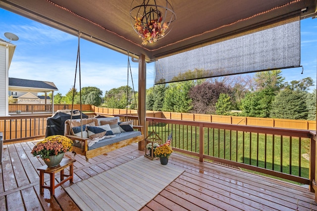 wooden terrace featuring a lawn and grilling area