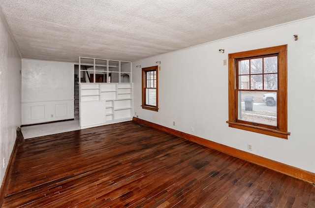 unfurnished room with built in features, dark hardwood / wood-style floors, and a textured ceiling