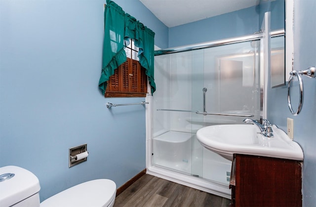 bathroom with a shower with shower door, sink, hardwood / wood-style floors, and toilet