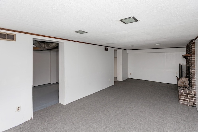 basement featuring a textured ceiling, carpet floors, and a fireplace