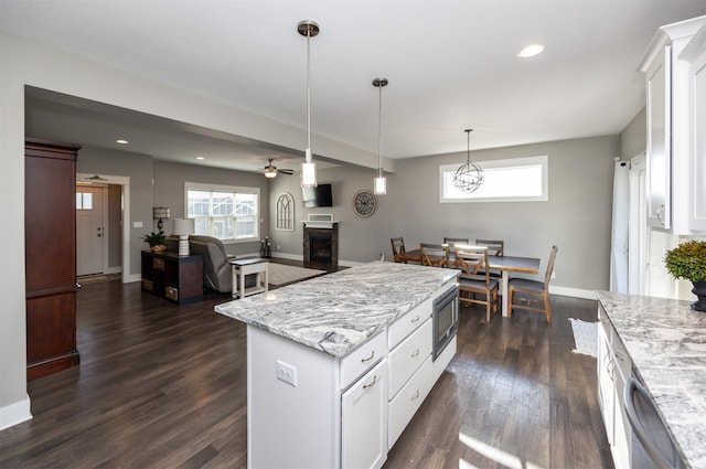 kitchen with pendant lighting, white cabinets, dark hardwood / wood-style flooring, and a kitchen island