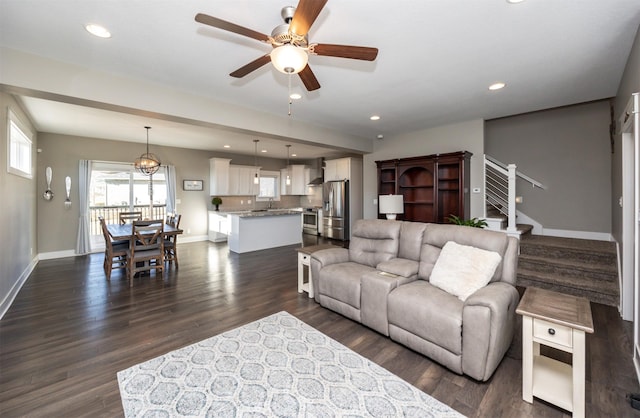 living room featuring ceiling fan and dark hardwood / wood-style floors