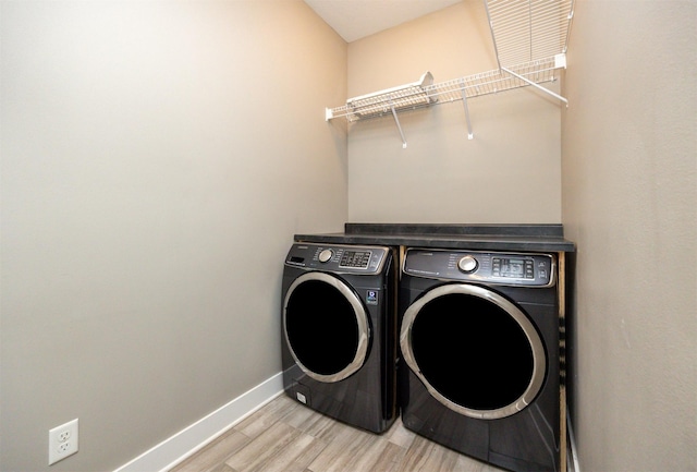 washroom with light hardwood / wood-style flooring and washing machine and dryer