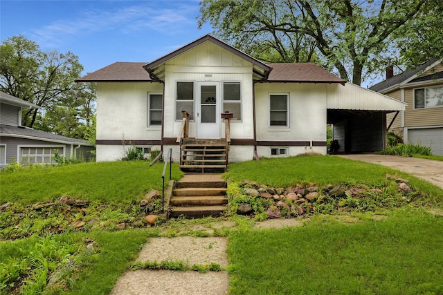 view of front of property featuring a front yard and a carport