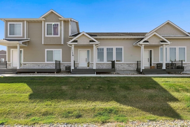 craftsman inspired home featuring central air condition unit and a front yard