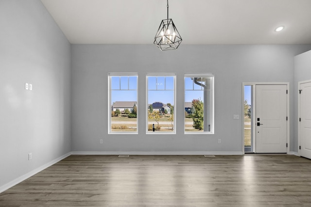 foyer entrance with dark wood-type flooring and an inviting chandelier