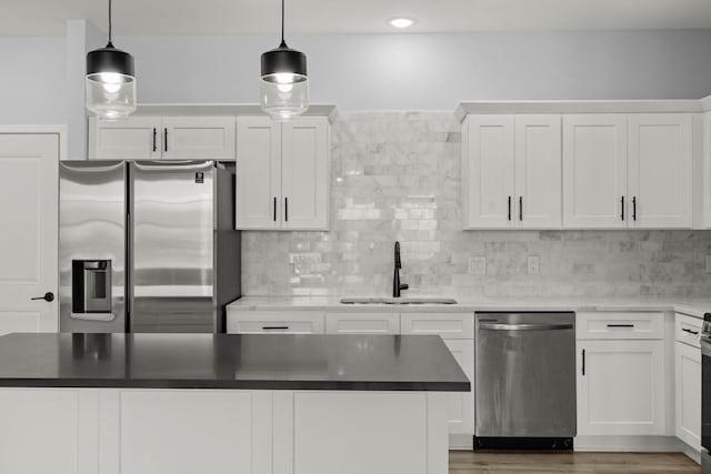 kitchen featuring sink, white cabinetry, hanging light fixtures, and appliances with stainless steel finishes