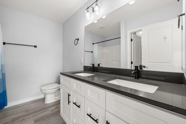 bathroom with a shower with curtain, hardwood / wood-style flooring, toilet, and vanity