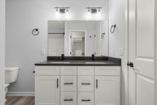 bathroom with hardwood / wood-style flooring, toilet, and vanity