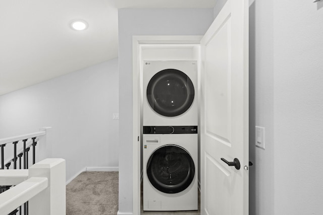 clothes washing area featuring light colored carpet and stacked washer and clothes dryer