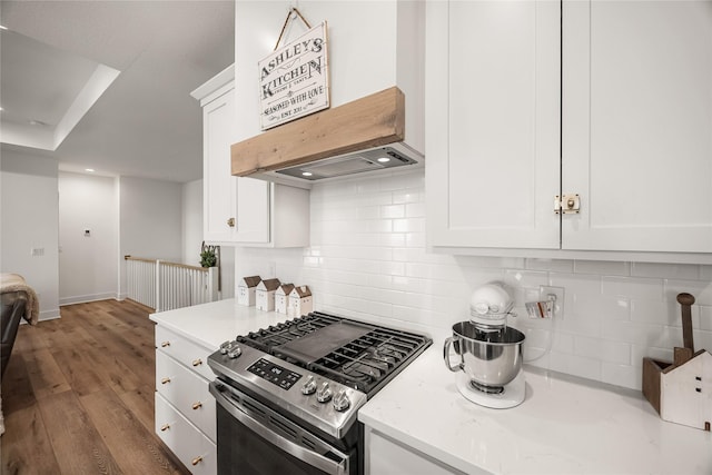 kitchen with stainless steel gas stove, light hardwood / wood-style floors, white cabinetry, and premium range hood