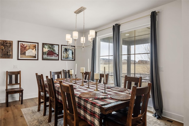 dining space with wood-type flooring and a chandelier