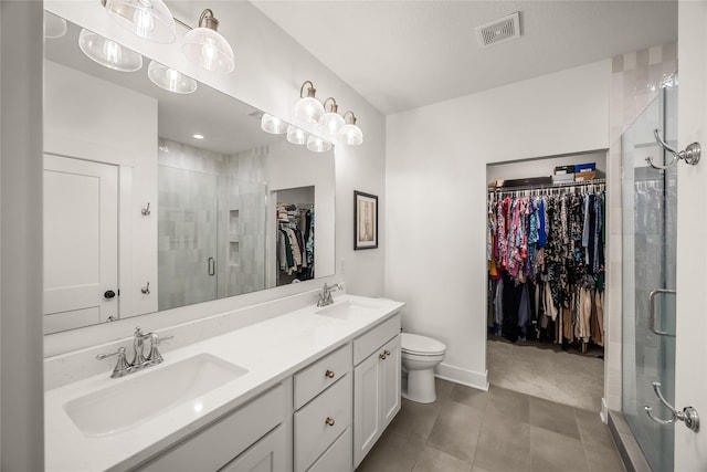 bathroom featuring toilet, a shower with door, and vanity