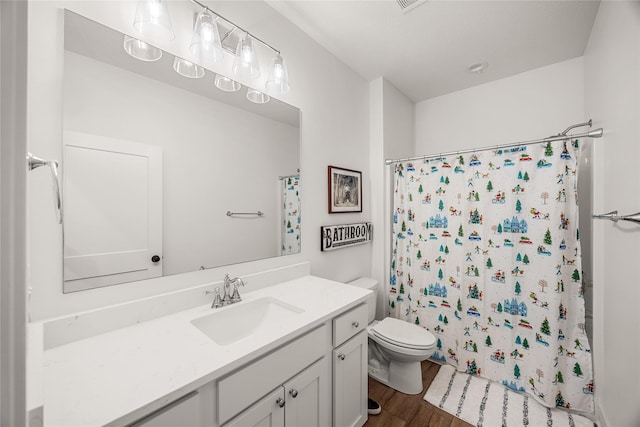 bathroom with wood-type flooring, toilet, a shower with shower curtain, and vanity